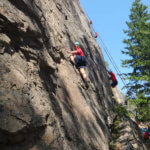 teen climbs up vertical rock face
