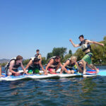 dark haired teen running across surfboards in the water