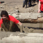 Photo Gallery: Man Crawling Underneath Log During Our Mudd, Sweat, and Tears Event