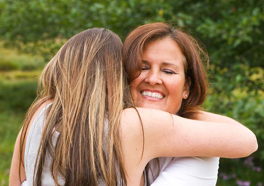 a girl hugs her mom