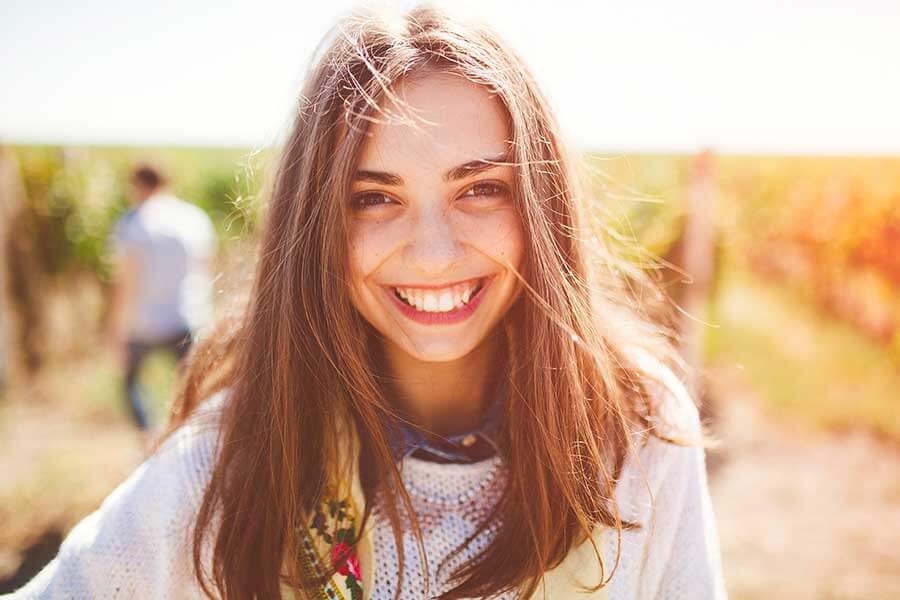 a smiling girl in a field for a youth profile