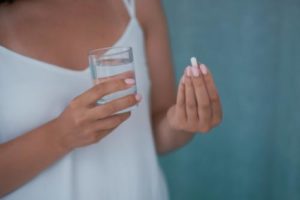 a woman prepares to take an opioid pill