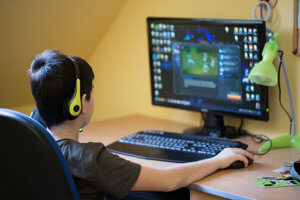 Young man on computer exhibiting signs of gaming addiction. 
