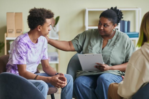 a counsellor in drug and alcohol treatment teaches teens about the negative side effects of marijuana abuse