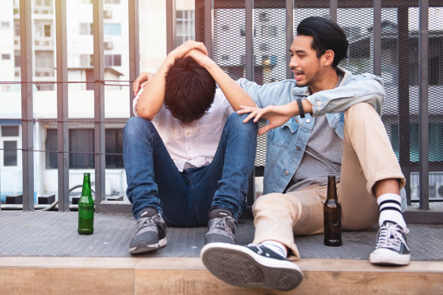 two teen boys engaged in underage drinking