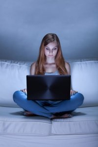 Young teen girl suffering from internet addiction disorder