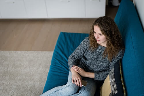 teen girl sits on a couch in residential treatment