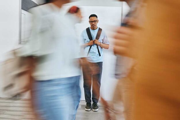 a teen struggles with a panic attack in a busy and crowded school setting