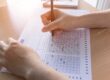 a teen fills out a test on a scantron at school