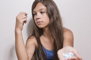 young teen female thinks about adderall addiction treatment as she takes another pill