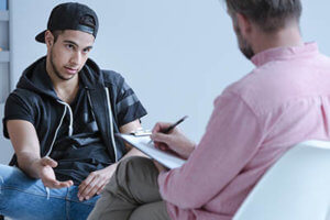male teen talks to counselor about teen substance abuse