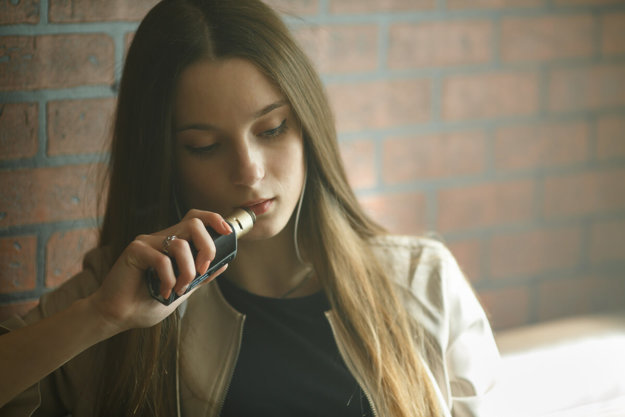 a girl vaping displaying the dangers of vaping and toking