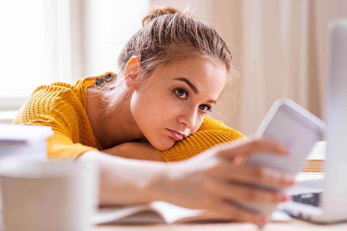 teen girl using phone uncaring of social media and mental health