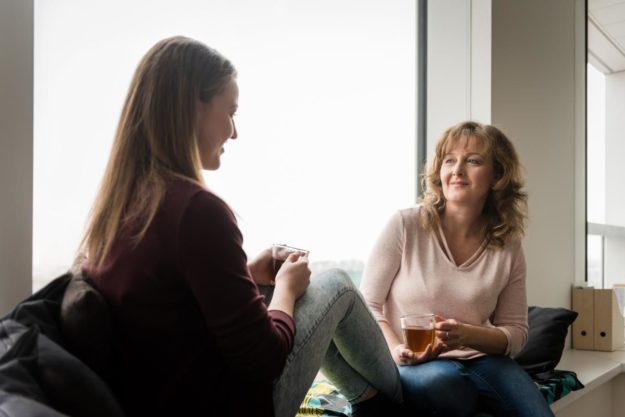 a therapist talks to a young woman about behavioural addiction treatment