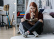 an angsty moody teen sits alone in her bedroom reading