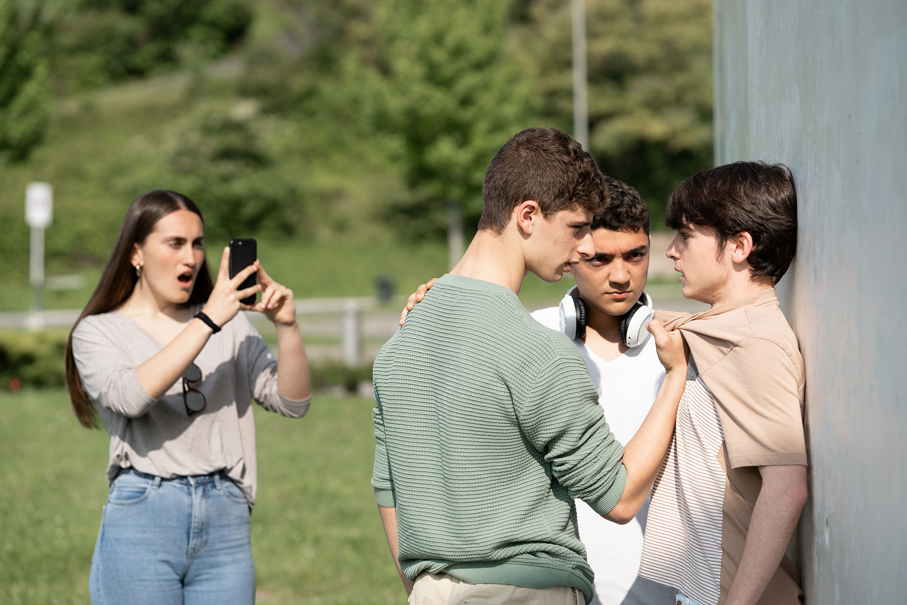 a teen bullies another child in front of others at school