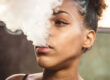 a teen blows out a cloud of cannabis smoke